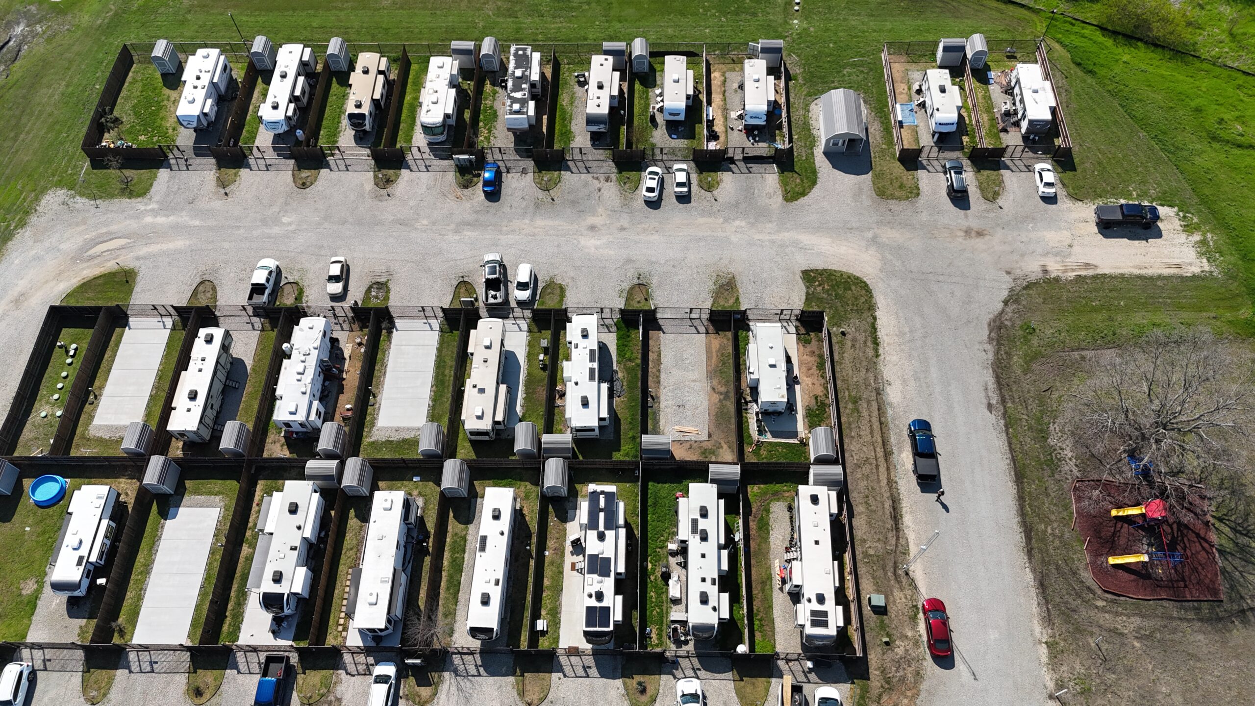 Aerial view of Desert Creek RV Estate showing rows of fenced, full-hookup sites with concrete pads