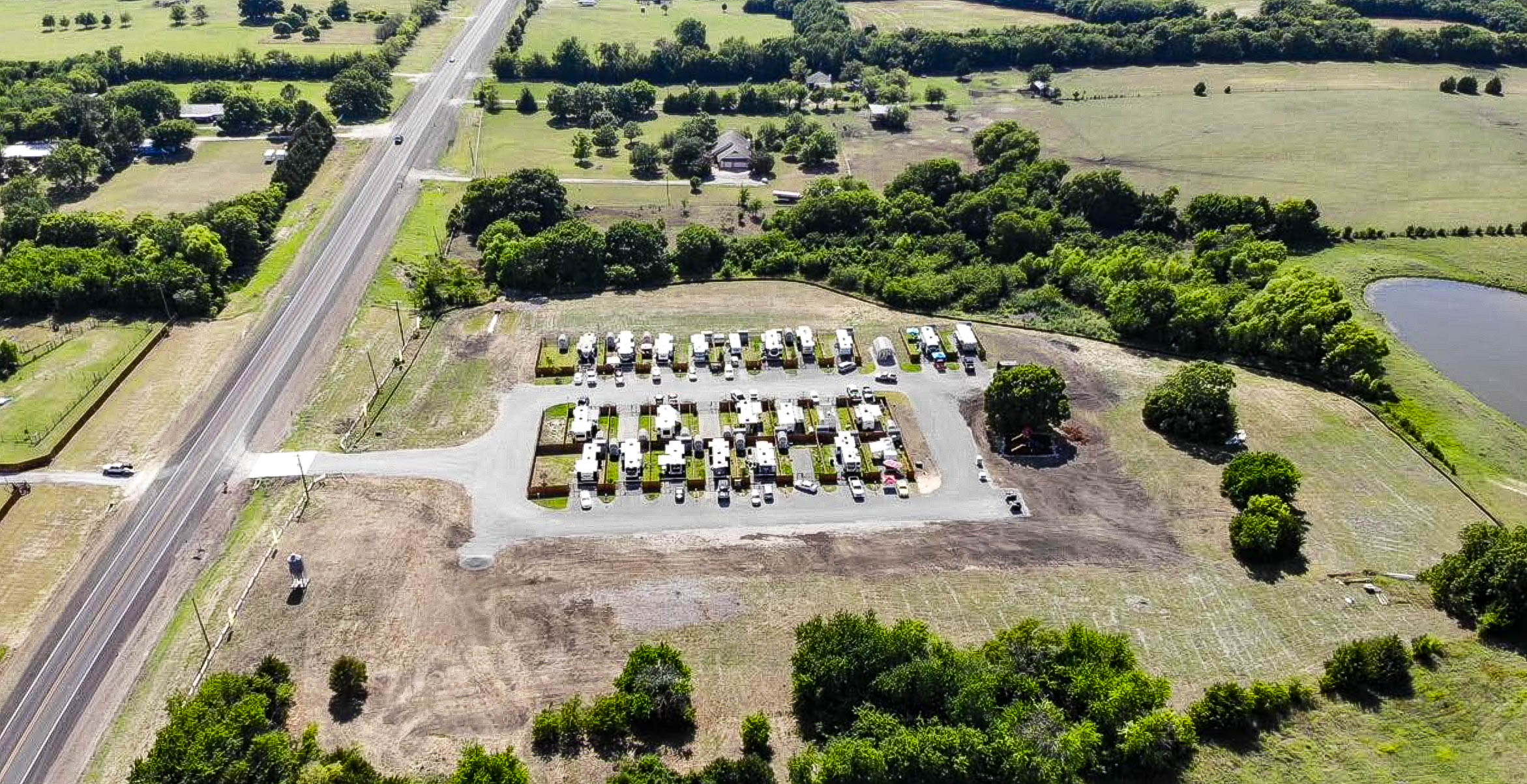Drone view of gated long-term RV sites with private fenced yards and storage sheds at Desert Creek RV Estate